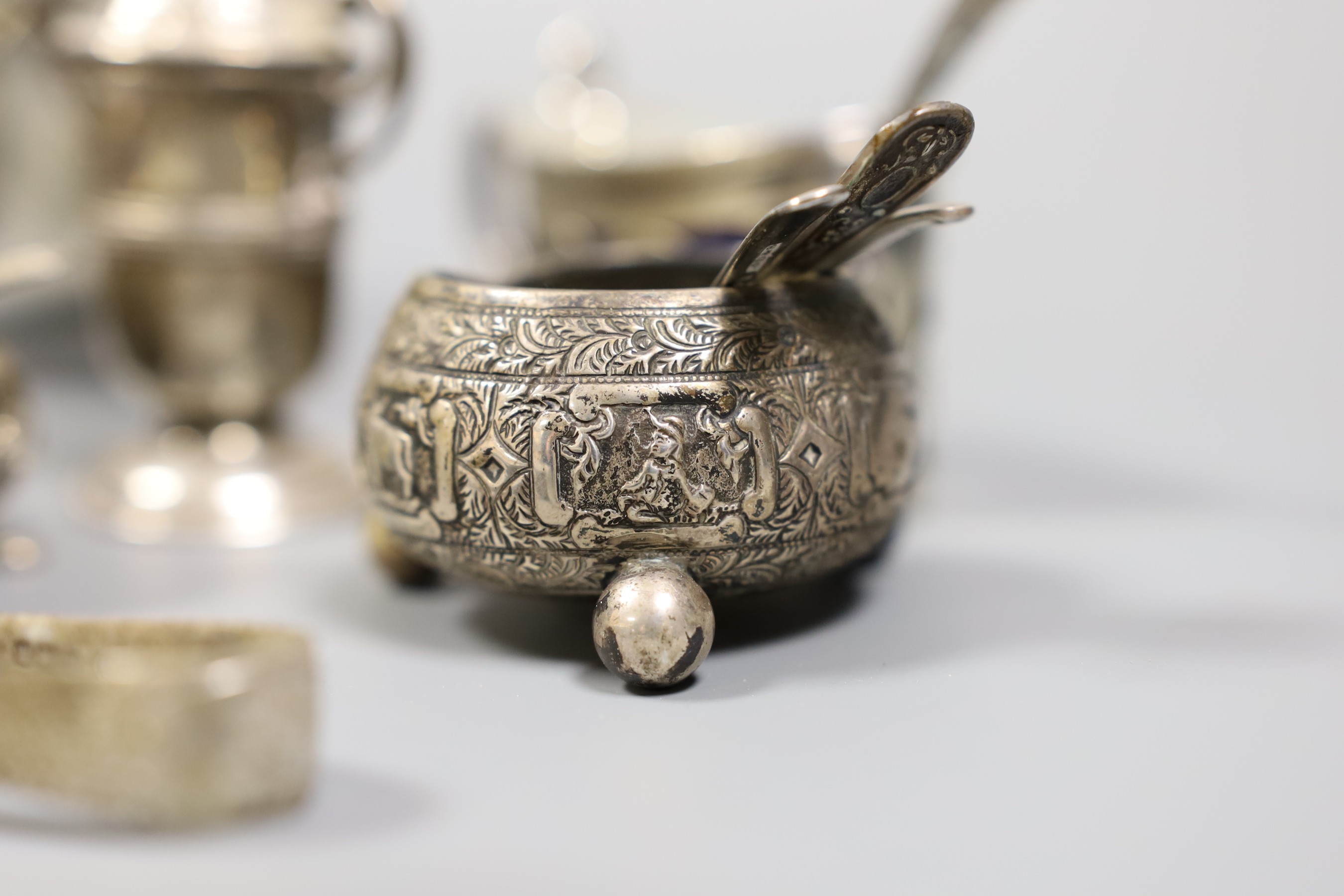 A small collection of mixed silver to include cased cutlery, a ladle, sauceboats, condiments, etc.